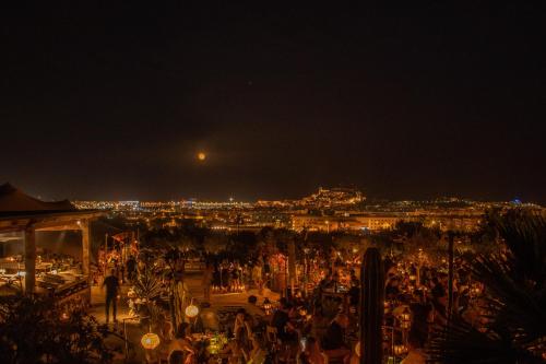 a crowd of people at night with the moon in the sky at Casa Maca in Ibiza Town