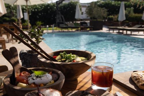 a table with bowls of food next to a swimming pool at Casa Maca in Ibiza Town