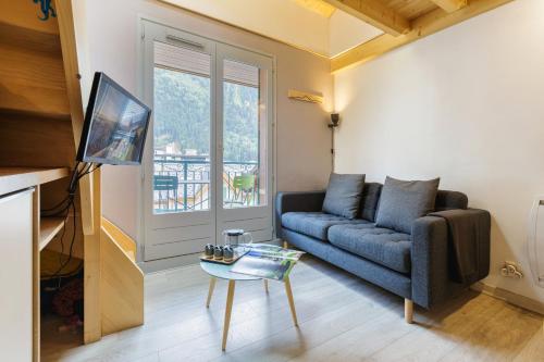un salon avec un canapé et une table dans l'établissement Central Duplex Apartment - Blanc Neige - Happy Rentals, à Chamonix-Mont-Blanc