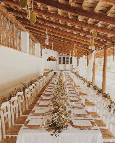 a long banquet hall with white tables and flowers at Casa Lucia in Sorrento