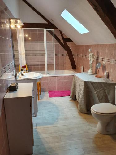 łazienka z umywalką, toaletą i wanną w obiekcie Gîte au coeur de la Touraine w mieście La Chapelle-sur-Loire