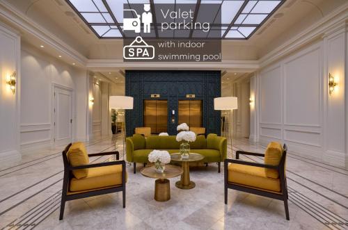 a lobby with a green couch and two chairs at Hotel Saski Krakow Curio Collection by Hilton in Krakow