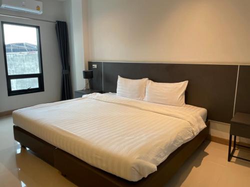にあるSinsiri hostelのベッドルーム1室(白いシーツが敷かれた大型ベッド1台、窓付)