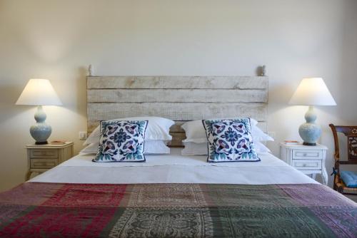 a bedroom with a large bed with blue pillows at La Bastide Neuve in Joucas