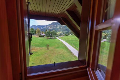 an open window with a view of a field and mountains at Chalet Ajda in Bohinj
