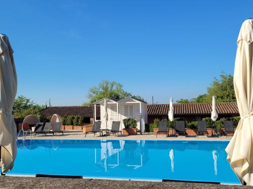 a pool with chairs and umbrellas at a resort at Relais Sant'Uffizio Wellness & Spa in Cioccaro