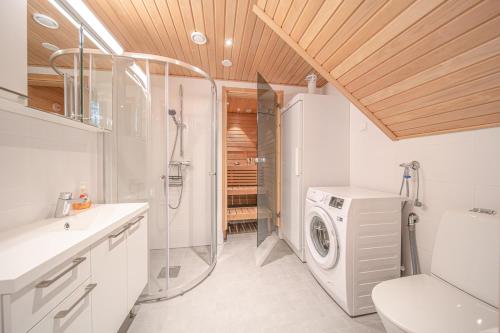 a bathroom with a shower and a washing machine at Levillas Sointuilevi 1 B67, 2 ski pass included in Levi