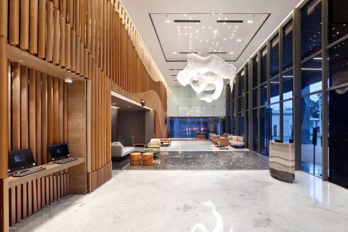hol biurowy z dużą marmurową podłogą i żyrandolem w obiekcie Hotel Aruss Semarang w mieście Semarang