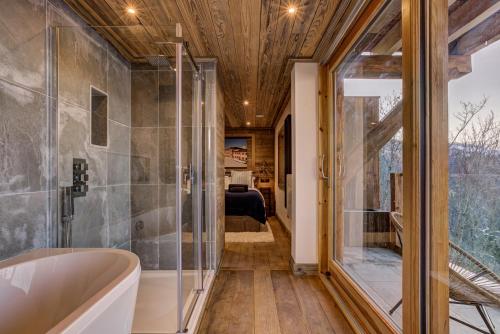 Un baño con bañera y un dormitorio. en Chalet Chèvrefeuille, en Saint-Gervais-les-Bains