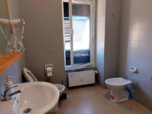 a bathroom with a sink and a toilet and a window at La dulce stanza in Genova