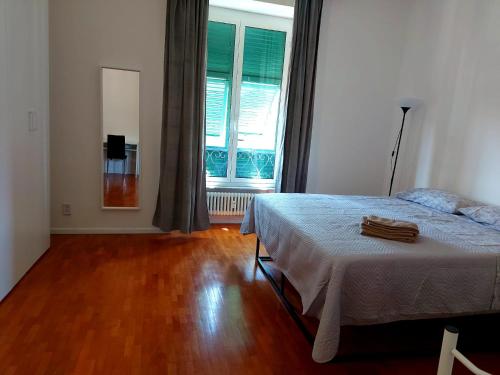 a bedroom with a bed and a large window at La dulce stanza in Genova