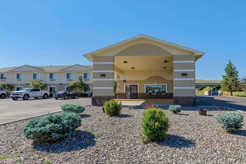 a building with bushes in front of a parking lot at Super 8 by Wyndham Big Timber in Big Timber