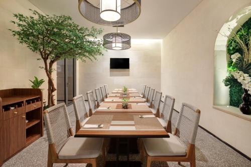 a long dining room with a long table and chairs at Hotel Aruss Semarang in Semarang