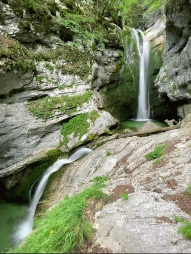 a waterfall on the side of a rocky cliff at Chalet Ajda in Bohinj