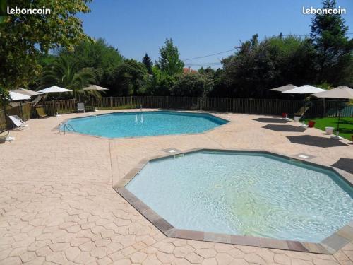 a large swimming pool in the middle of a patio at MOBIL-HOME NEUF 6 PERSONNES réservation du samedi au samedi en juillet et août in Urt