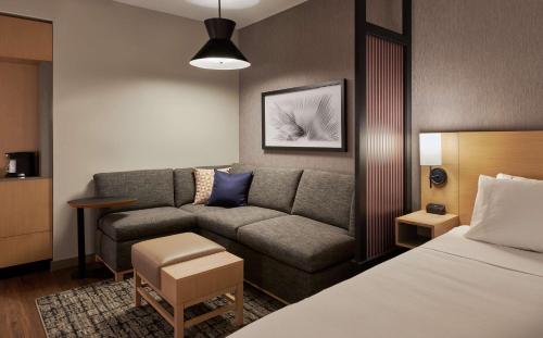 a living room with a couch and a bed at Hyatt Place Asheville Airport in Arden