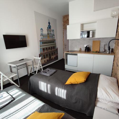 um quarto com uma cama, uma mesa e uma cozinha em Rybaki 6A em Poznań
