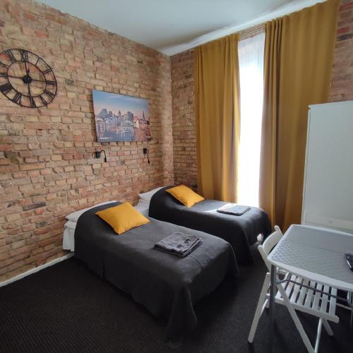 um quarto com duas camas e uma parede de tijolos em Rybaki 6A em Poznań