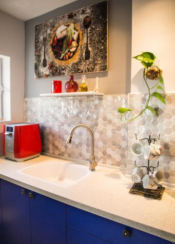 a kitchen with a sink and a red appliance at On the Edge of a Crater in Mitzpe Ramon