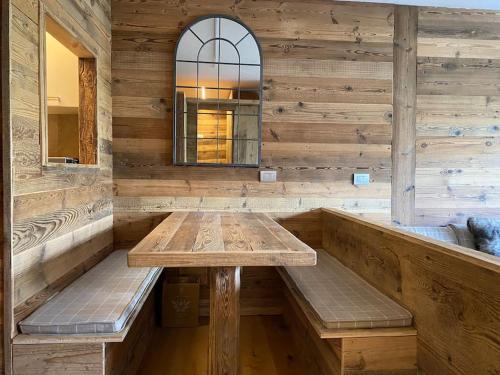 a wooden room with a wooden table and benches at Incantevole appartamento stile chalet Breuil Cervinia in Breuil-Cervinia