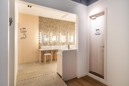 a bathroom with a sink and a mirror at eeGee STAY Kamata in Tokyo