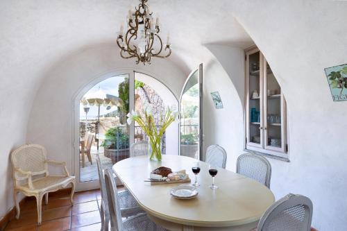 une salle à manger avec une table, des chaises et un lustre dans l'établissement CASA SANTA MARIA, à Santa-Reparata-di-Balagna