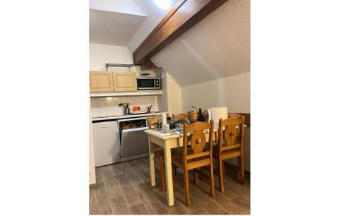 - une cuisine avec une table et des chaises dans la chambre dans l'établissement Résidence Lumières de Neige 2 - maeva Home, à Valmeinier