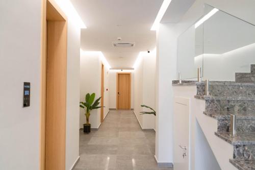 einen Flur mit weißen Wänden und eine Treppe mit Topfpflanze in der Unterkunft HOTEL PATIO in Vlorë