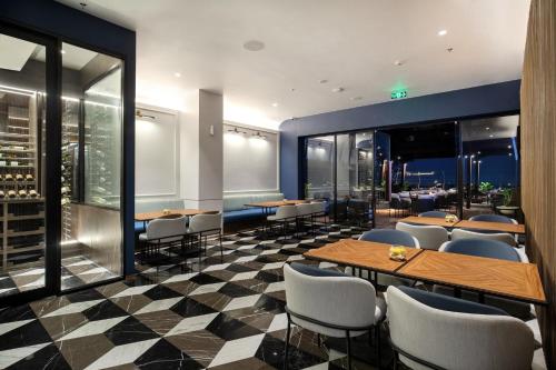 a restaurant with tables and chairs on a checkered floor at Hotel Aruss Semarang in Semarang