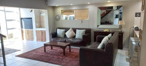 een woonkamer met een bank en een tafel bij Waterfront G8 Swakopmund in Mondesa