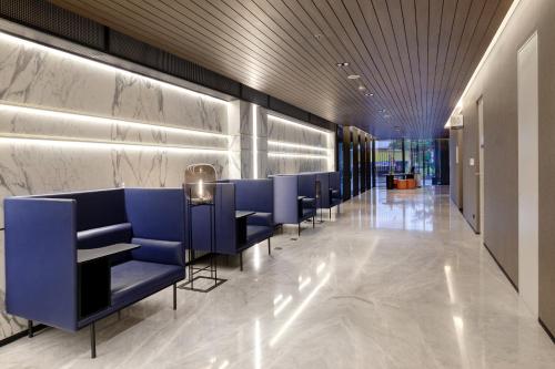 a row of blue chairs in a lobby at Hotel Aruss Semarang in Semarang