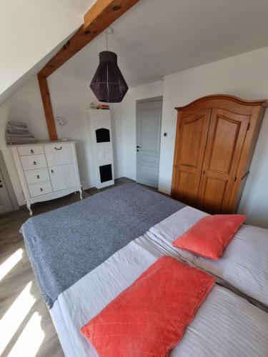 a bedroom with a bed with two red pillows on it at Marių vėjas in Nida