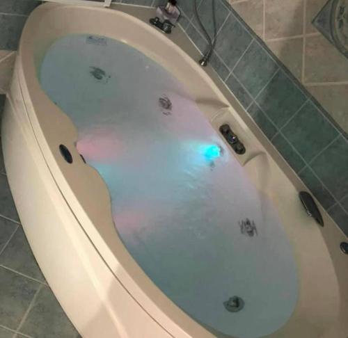 bañera blanca con luz azul en Gold Luxury House, en Anzio