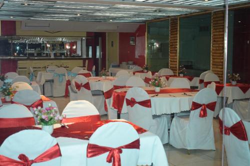 a banquet hall with white tables with red bows at Hypertek Guesthouse in Grand Baie