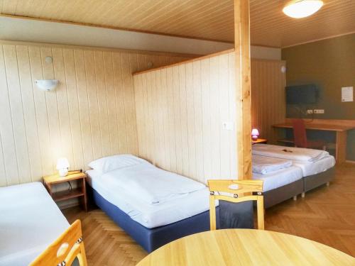 two beds in a room with two tables and a table at Pension Zuser in Mitterbach