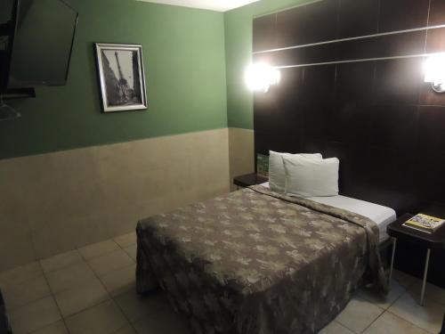 a bedroom with a bed and a green wall at Hotel Metropolitano Tampico in Tampico