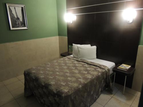 a small room with a bed and two lights at Hotel Metropolitano Tampico in Tampico
