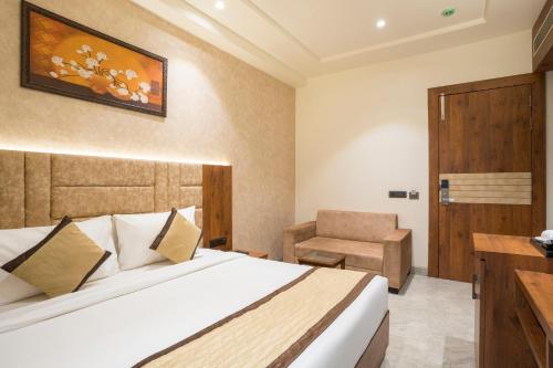 um quarto de hotel com uma cama e uma cadeira em THE TAJ PEARL HOTEL em Agra