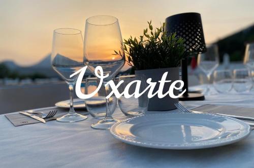 una mesa con copas de vino y un plato en ella en Pension Uxarte, en Arrasate - Mondragón