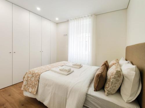 um quarto branco com uma cama com paredes brancas em Senhora da Agonia - Apartment in Ribeira em Viana do Castelo