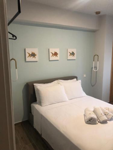 a bedroom with a white bed with three pictures on the wall at ATHONITE all seasons luxury suites in Ierissos