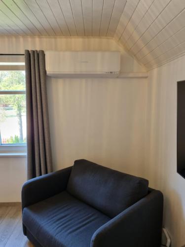 a blue couch in a living room with a window at Marių vėjas in Nida