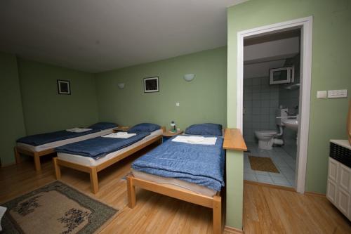 two beds in a room with a bathroom at Rooms with a parking space Tordinci, Slavonija - 15159 in Tordinci