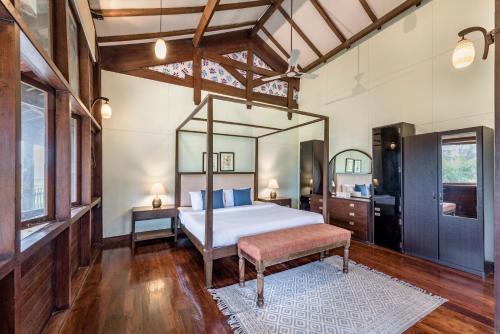 1 dormitorio con 1 cama grande y espejo en SaffronStays Boulevard LogHouse - a wooden chalet amidst nature, en Kārli