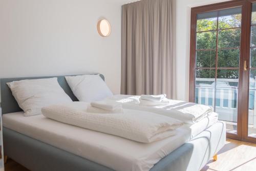 Cama blanca en habitación con ventana en Haus Trudi en Walchsee
