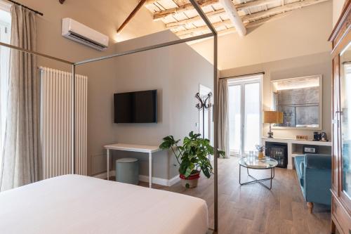 a bedroom with a bed and a table in a room at Vossia Luxury Rooms & Sicilian Living in Palermo
