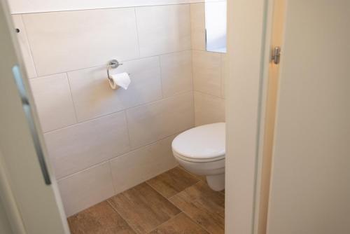 a bathroom with a toilet and a toilet paper dispenser at Haus Trudi in Walchsee