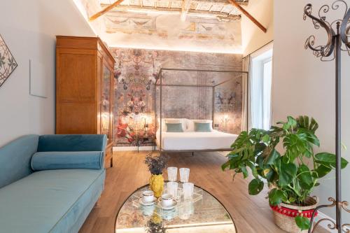 sala de estar con sofá azul y cama en Vossia Luxury Rooms & Sicilian Living, en Palermo