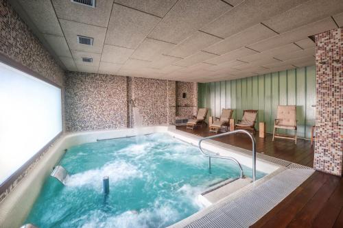 a jacuzzi tub in a room with tables and chairs at Hotel La Vida Spa in Aldeayuso