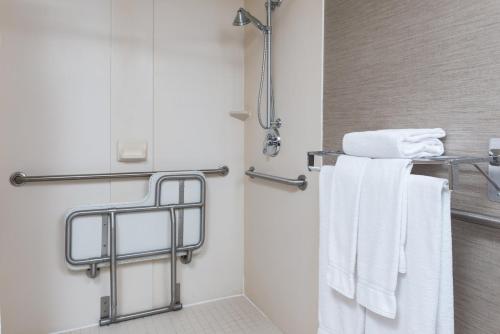 La salle de bains est pourvue d'une douche et de serviettes blanches. dans l'établissement Holiday Inn Express Hotels & Suites Burlington, an IHG Hotel, à Burlington